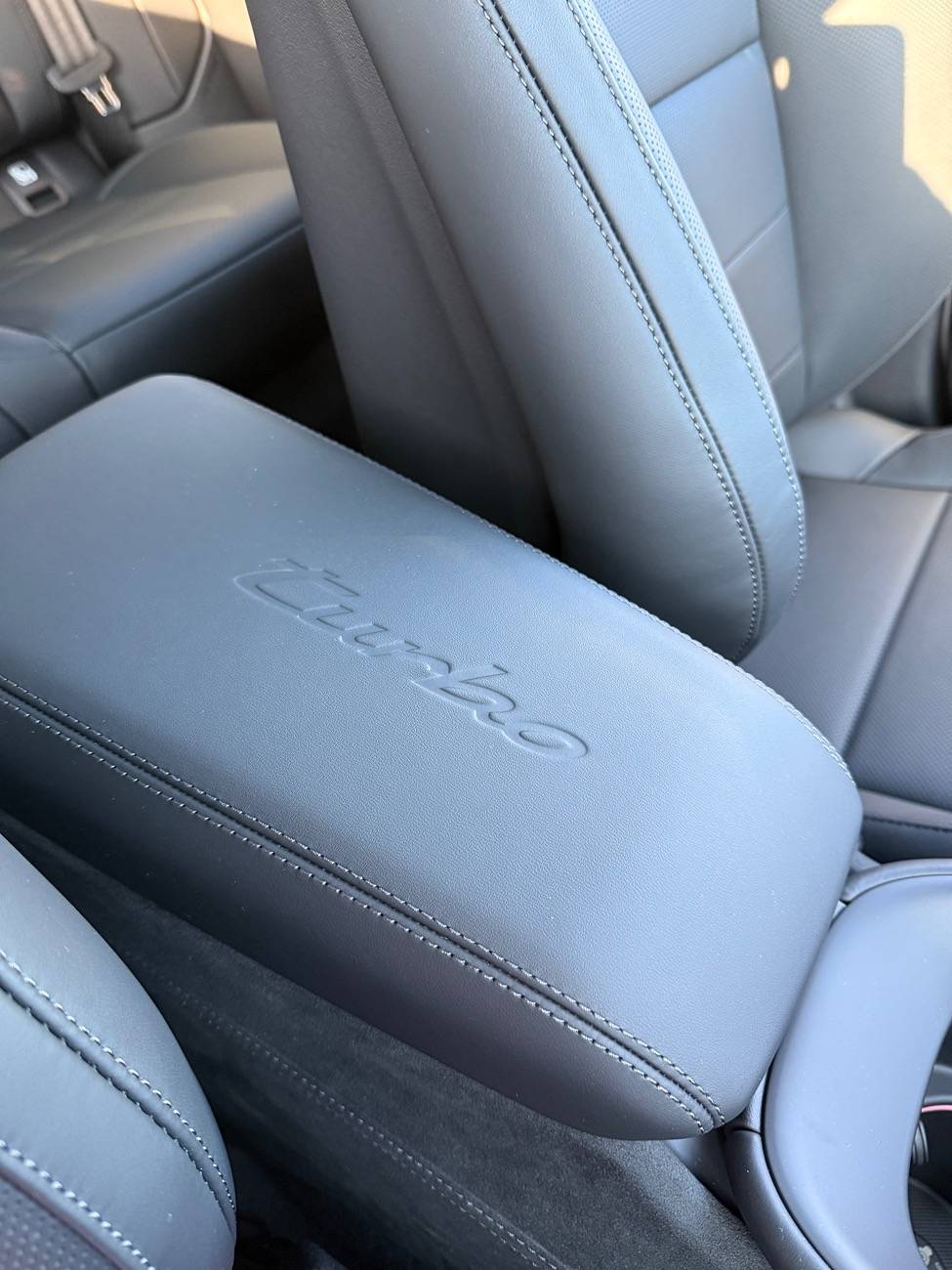 Electric Macan EV Photos: model logo on center armrest and race-tex center console frame IMG_4396